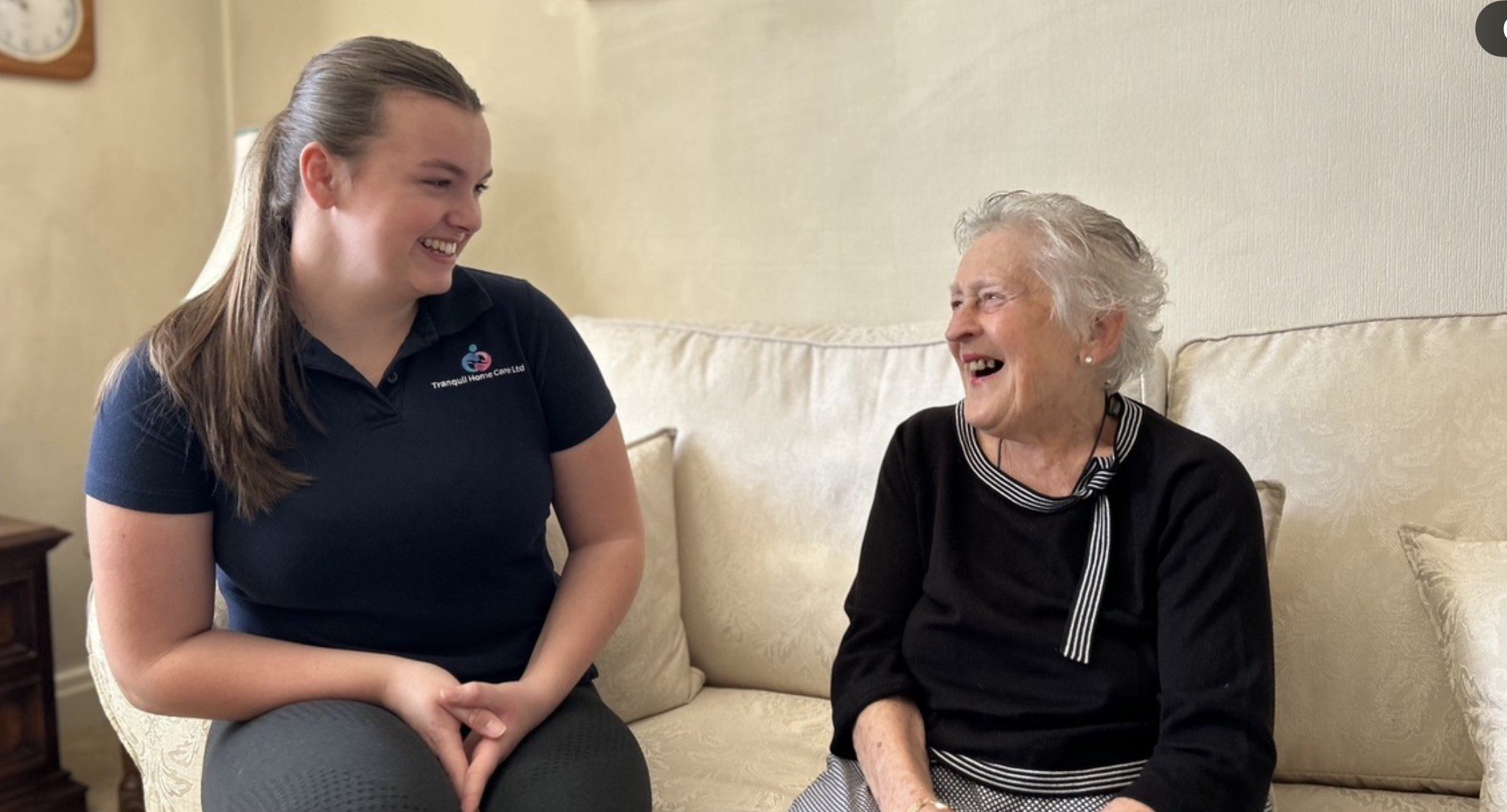 Young woman and elderly woman laughing together.